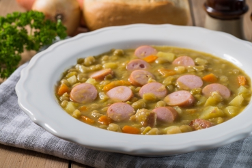 Frische Erbsensuppe mit Würstchen und Croûtons